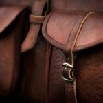 Close up of side pocket on a generic brown leather bag with a rustic design and fine stitching