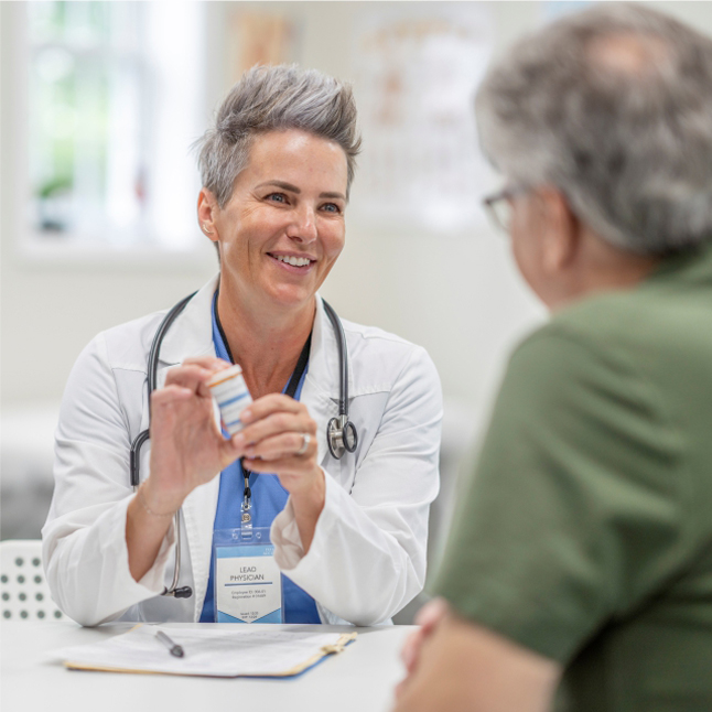 Doctor holding medicine talking to someone