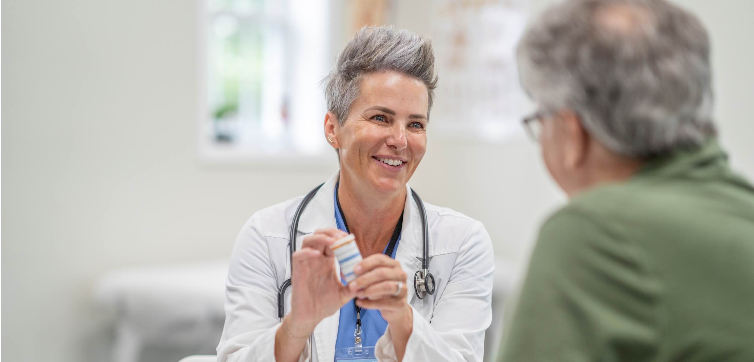 Doctor holding medicine explaining to patient